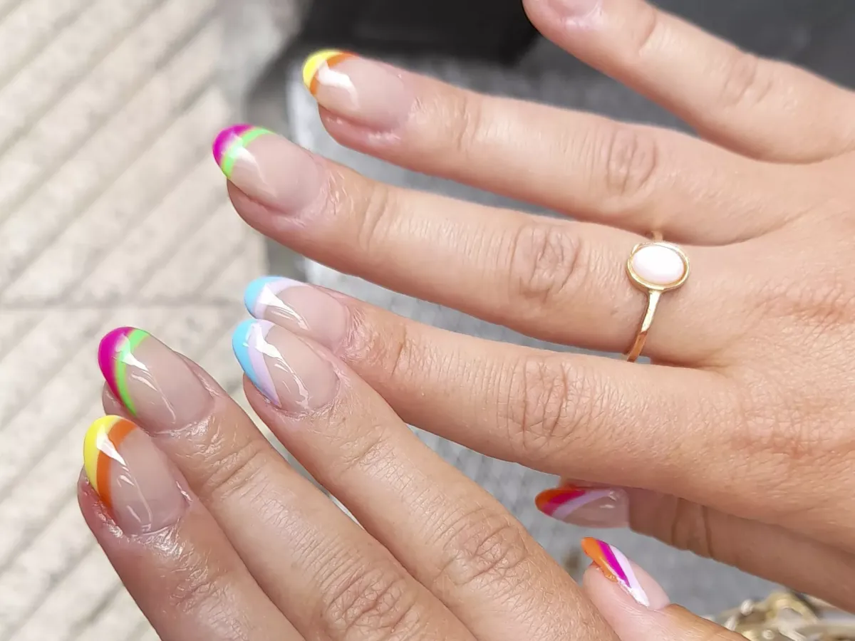 Manicura uñas con base de refuerzo pintadas tonos rosa, azul, amarillo, naranja...